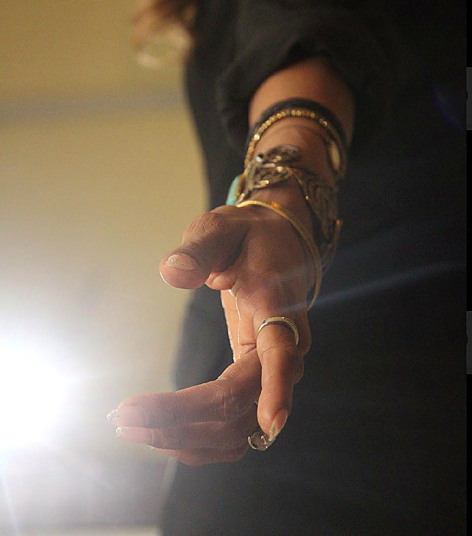 An open hand reaching into the light